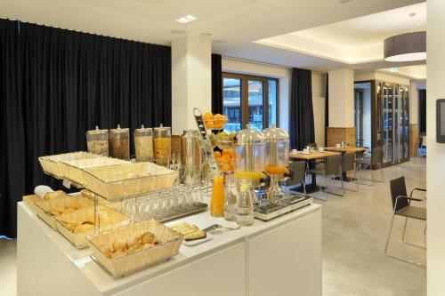 a buffet line with food and drinks in a lobby at Bayer 89 Vi Vadi Hotel in Munich