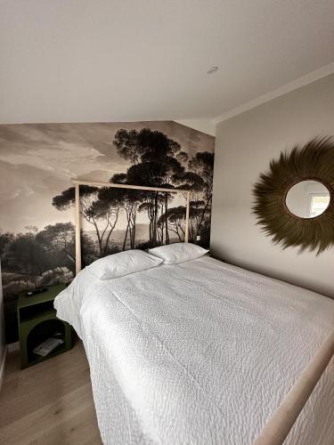 a bedroom with a bed with a painting on the wall at L'Opale - Le Jungle in Les Attaques