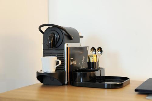 a coffee maker and a cup on a table at Bayer 89 Vi Vadi Hotel in Munich
