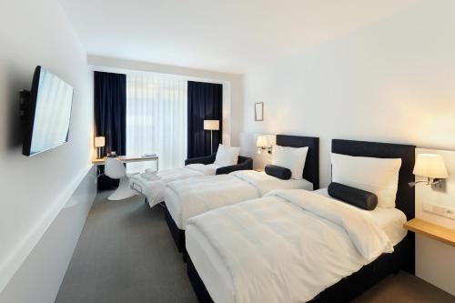 a hotel room with four beds in a room at Bayer 89 Vi Vadi Hotel in Munich