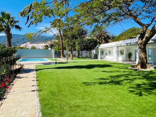 un gran patio con piscina y una casa en Malibú Ocean Villa, en Santa Cruz de Tenerife