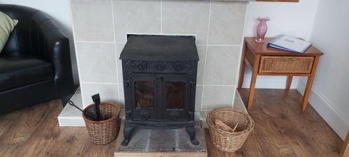 a stove in a living room with a couch and a table at Newmarket in Stornoway