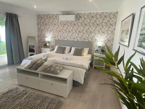 1 dormitorio con 1 cama blanca grande y 2 mesas en Malibú Ocean Villa, en Santa Cruz de Tenerife