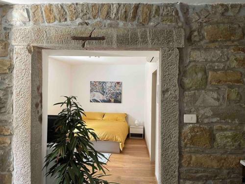 1 dormitorio con cama y pared de piedra en Santomas apartments, en Šmarje