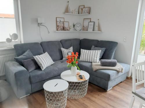 a living room with a blue couch and a table at Wiesenschlössle in Sagard