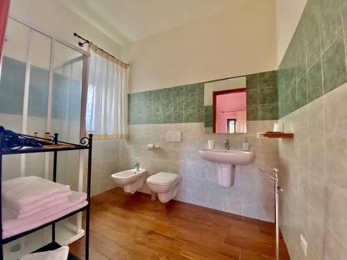 a bathroom with a sink and a toilet and a mirror at La Porta delle Gole in Motta Camastra