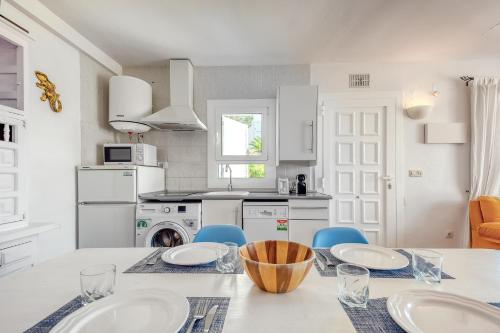 a kitchen with a table and blue chairs in a kitchen at Mimoses B 2 Canyelles Roses - Immo Barneda in Montjoys