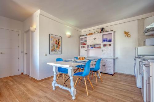 a kitchen with a white table and blue chairs at Mimoses B 2 Canyelles Roses - Immo Barneda in Montjoys