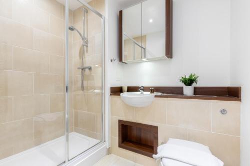 W łazience znajduje się prysznic i umywalka. w obiekcie The Canada Water Flat w Londynie