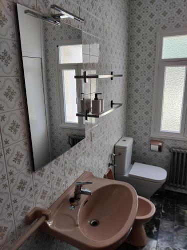 a bathroom with a sink and a toilet and a mirror at Casa A Mariña in Barreiros