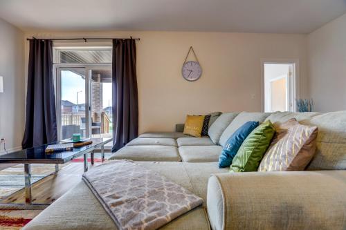 a living room with a couch and a clock on the wall at GLOBALSTAY New houses near Huron Lake in Port Elgin