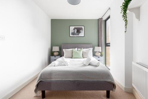 sypialnia z łóżkiem z białą pościelą i poduszkami w obiekcie The Canada Water Flat w Londynie