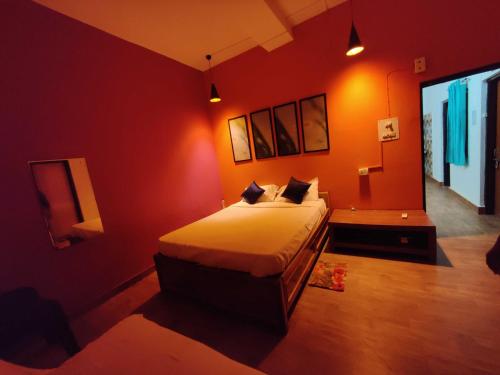 a bedroom with a bed in a red room at Housefull Residency in Khandagiri