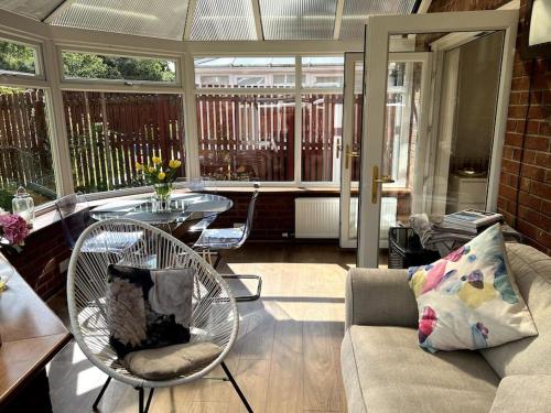 a living room with a couch and a chair and a table at Home2Home Meadow House in East Kilbride