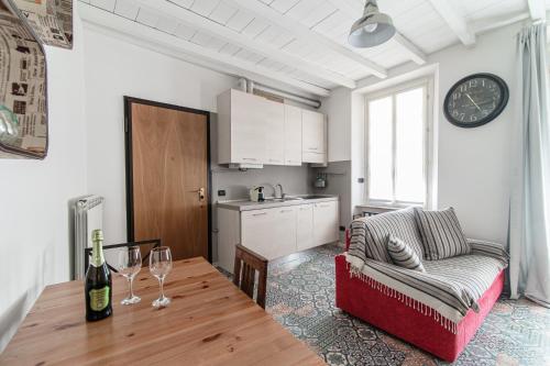 a kitchen and living room with a table and a couch at Orange Suite - The House Of Travelers in Como