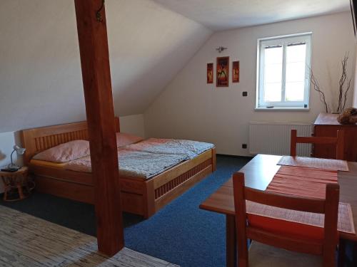 a bedroom with two beds and a table and a window at Ekofarma Šťástkovi in Jindřichŭv Hradec