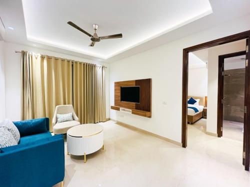 sala de estar con sofá azul y TV en Inception Residence, en Gurgaon