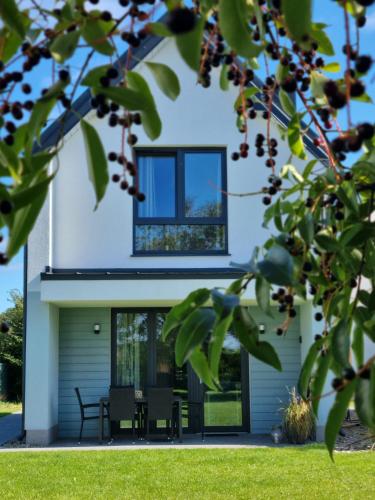 ein Haus mit einem Fenster an der Seite in der Unterkunft Siedlisko na wydmach, sauna,podgrzewane jacuzzi,domki klimatyzowane,starlink internet,parking in Łeba