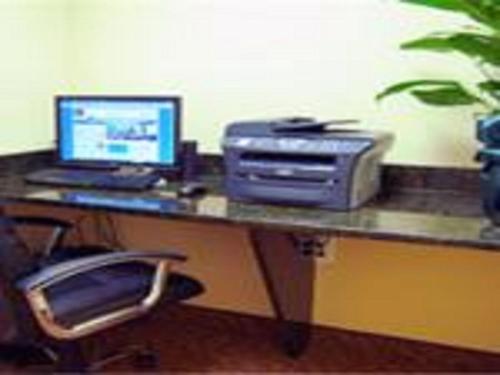 a desk with a computer monitor, keyboard and mouse at Days Inn by Wyndham North Mobile in Mobile