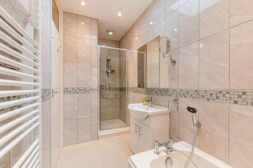 a bathroom with a sink and a shower and a toilet at The Tea House - A Stones Throw From Beach in Broadstairs