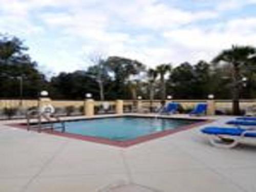 a swimming pool with blue lounge chairs at Days Inn by Wyndham Semmes Mobile in Mobile