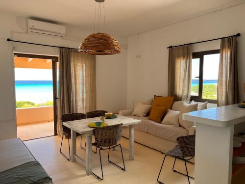 ein Wohnzimmer mit einem Sofa und einem Tisch mit Stühlen in der Unterkunft Arenas del Mar Formentera in Es Arenals