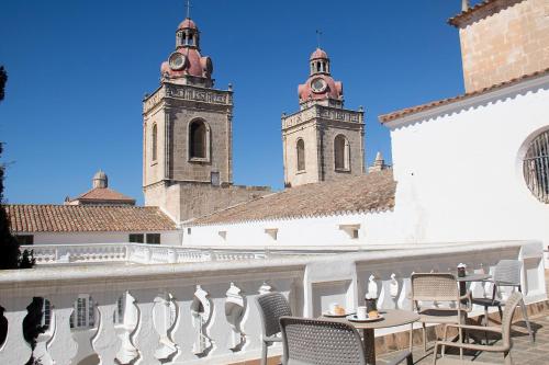 a balcony with chairs and tables and two towers at Grupoandria El Claustre de Ciutadella - HOSPEDERIA in Ciutadella