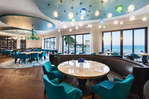 a restaurant with tables and chairs and the ocean in the background at Vila Vita Parc Resort & Spa in Armação de Pêra