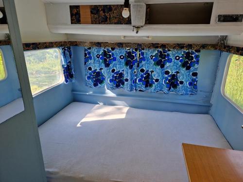 une chambre vide dans un salon avec une fenêtre dans l'établissement Camping La Fôret du Morvan Vintage caravan, à Larochemillay