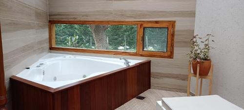 y baño con bañera y ventana. en Casa Golf en Sierra de los Padres