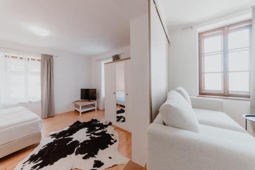 a white room with a white couch and a mirror at Apartmány Staré Město in Znojmo