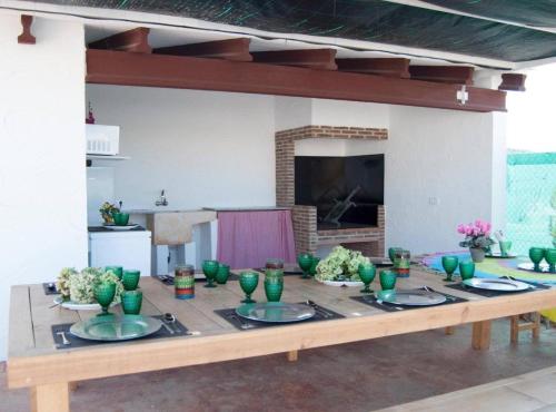 ChellaにあるCasa Rural Frigolsの木製テーブル(緑の鉢、皿付)