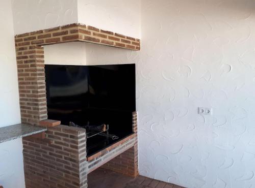 a fireplace in a living room with a brick wall at Casa Rural Frigols in Chella