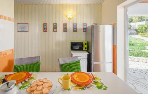 een keuken met een tafel met borden en een koelkast bij Pet Friendly Home In Ravni With House Sea View in Ravni