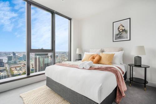 um quarto com uma grande cama branca e janelas grandes em Elegant 1B apt in central Melbourne w unreal view#PA4303 em Melbourne