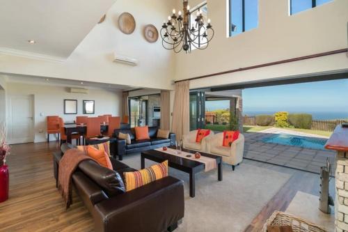 a living room filled with furniture and a pool at SW2 - Pezula Luxury Villa in Knysna