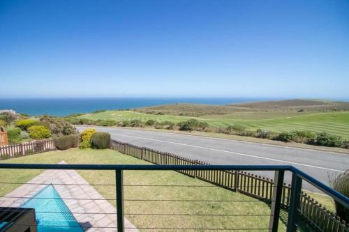a balcony with a view of a road and the ocean at SW2 - Pezula Luxury Villa in Knysna