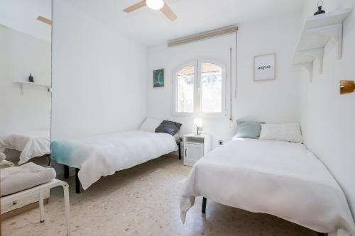 um quarto branco com 2 camas e uma janela em BHost - Wilkinson em Málaga