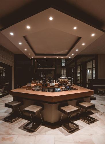 a large kitchen with a large island with stools at Apollo Resort in Agia Marina Aegina