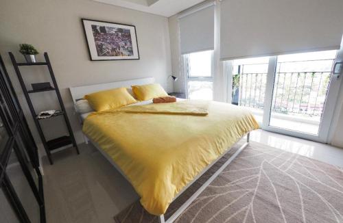a bedroom with a large bed with a yellow blanket at Breeze Home in Pondoklang