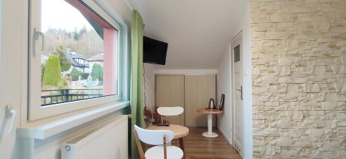 a room with a window and two chairs and a table at Zielona Noc in Polanica-Zdrój