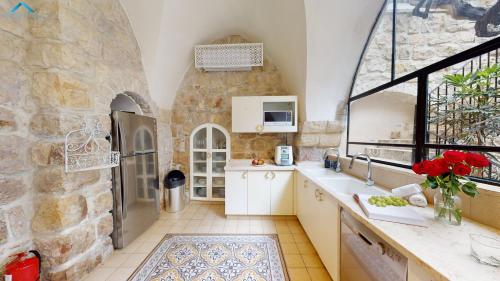 a kitchen with a large stone wall at VILLA MAMILLA - Boutique suites in Jerusalem