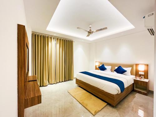 a bedroom with a large bed with blue pillows at Inception Residence in Gurgaon