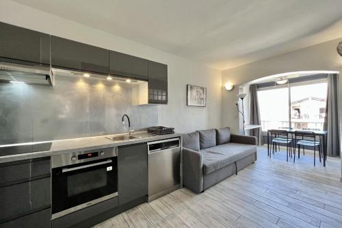 - une cuisine avec un canapé, un évier et une table dans l'établissement Bright 26 m with pool in Frejus, à Fréjus