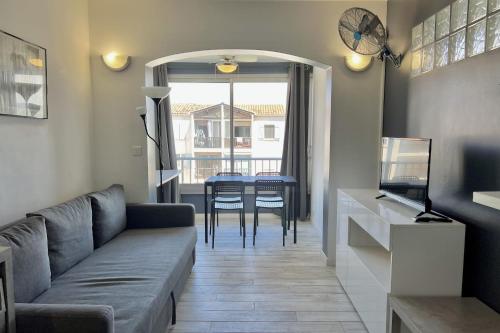 un salon avec un canapé et une table dans l'établissement Bright 26 m with pool in Frejus, à Fréjus