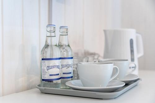 two bottles of water and a cup on a tray at Apartamenty Defala i Strefa Relaksu Natural Touch in Rymanów-Zdrój