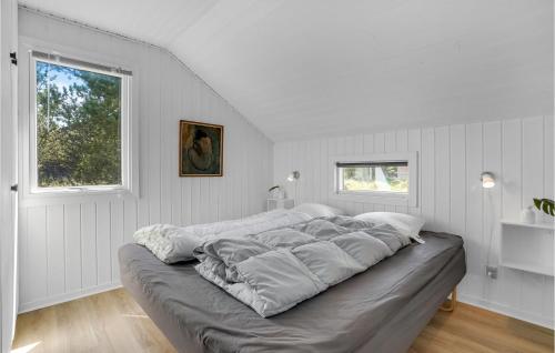 a large bed in a white room with a window at 3 Bedroom Pet Friendly Home In Blvand in Blåvand