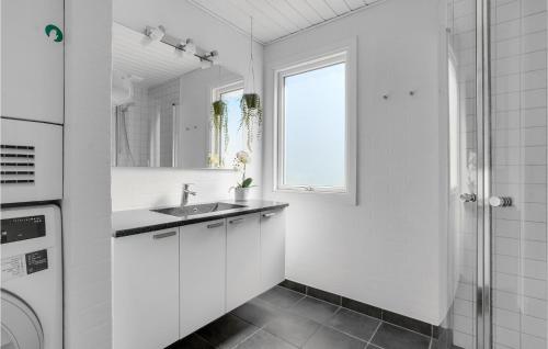 a white bathroom with a sink and a shower at 3 Bedroom Pet Friendly Home In Blvand in Blåvand