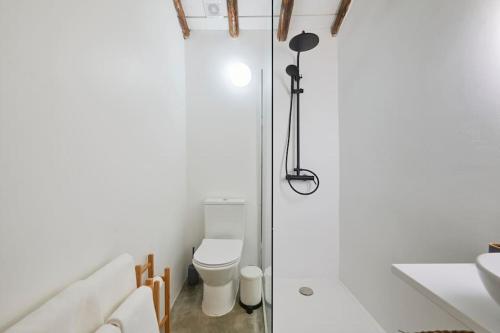 uma casa de banho com um WC e uma porta de duche em vidro. em Rustic & Aesthetic House in Alqueva with Pool em Granja