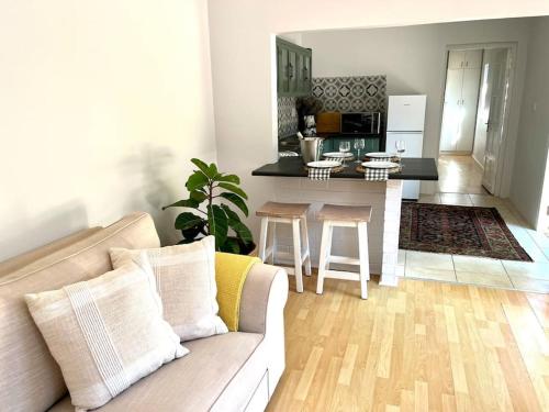 uma sala de estar com um sofá e uma cozinha em Stirling Cottage em Durban